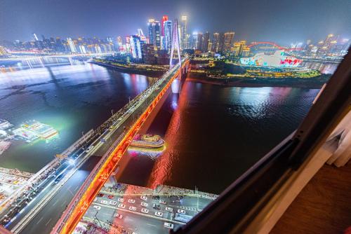 a view of a city at night with a river at Misty Nest High Altitude River View B&B Hongyadong Branch in Chongqing