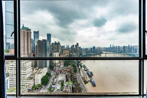 a view of a city from a window at Misty Nest High Altitude River View B&B Hongyadong Branch in Chongqing
