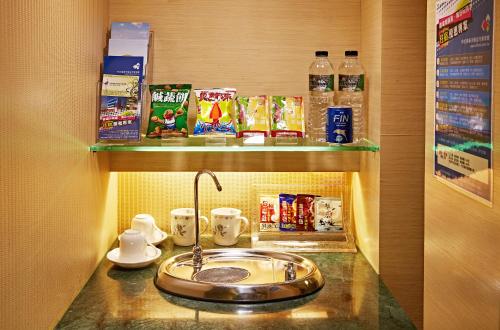 a bathroom counter with a sink and some drinks at 薇風情汽車旅館 - 台南館 in Liujia