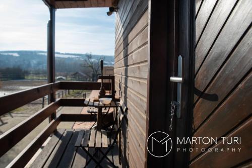 a door to a balcony with a table and chairs at Lovas Udvarház Ezüst Zabla Apartman Piliscsaba in Piliscsaba