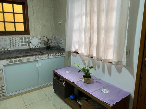 a kitchen with a table with a plant on it at Eplantae - Cabo frio - RJ in Cabo Frio