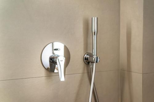 a shower with a mirror on a wall at Arches Apartments in Athens