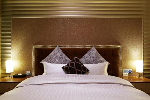a bedroom with a large bed with two lamps at 薇風情汽車旅館 - 台南館 in Liujia