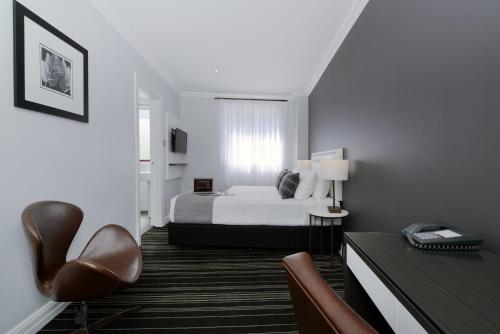 a hotel room with a bed and a desk and chair at Perouse Randwick by Sydney Lodges in Sydney