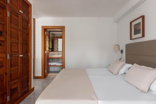 a bedroom with two beds and a bathroom at Parque Santiago III Official in Playa de las Americas