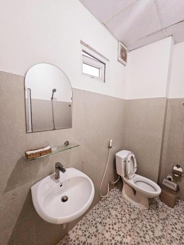 a bathroom with a sink and a toilet and a mirror at La Mer Mũi Né Hotel in Ấp Thiện Long