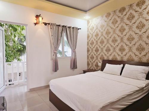 a bedroom with a large bed and a window at La Mer Mũi Né Hotel in Ấp Thiện Long