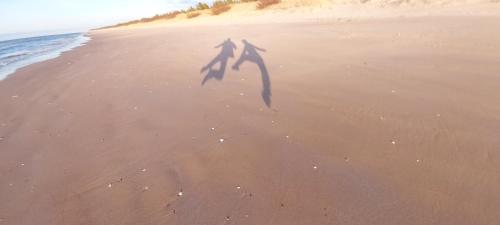 two shadows of two people on the beach at Randas1 in Lielirbe