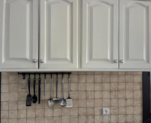 a kitchen counter with white cabinets and utensils at Villa a oued alien in Tangier