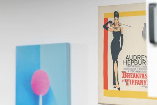 un poster di una donna in abito nero su un muro di Wyjątkowe Jasne Studio w Centrum Poznania by Noclegi Renters a Poznań