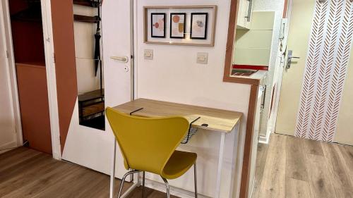 une chaise jaune assise à côté d'un bureau dans une pièce dans l'établissement 093 - Le Terracotta -2 pers-Parking - Proche du centre, à Montpellier