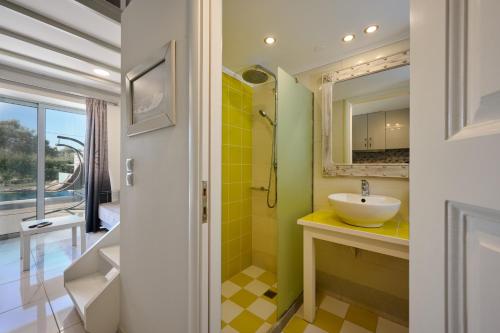 a bathroom with a sink and a mirror at Kastro Suites in Lefkada