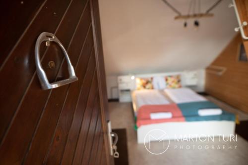 a door to a bedroom with a bed in a room at Ezüstkengyel Apartman in Piliscsaba