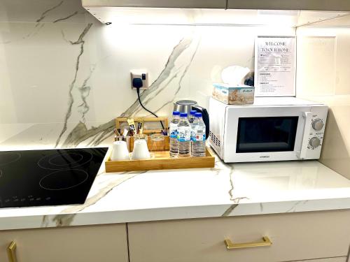 a kitchen counter with a microwave and some bottles of water at Stunning Studio with Sea-View in Jumeirah Lake Towers JLT in Dubai