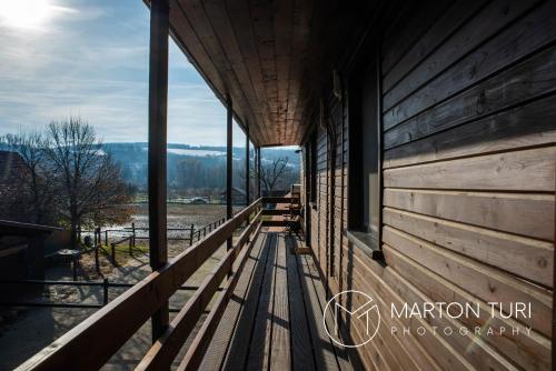 a porch of a wooden building with a view at Ezüstkengyel Apartman in Piliscsaba