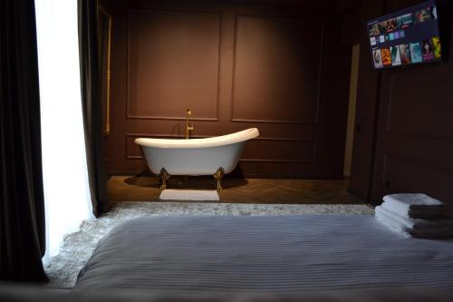 a bath tub in a bathroom with a bed at Park Gate apartment in Chernivtsi