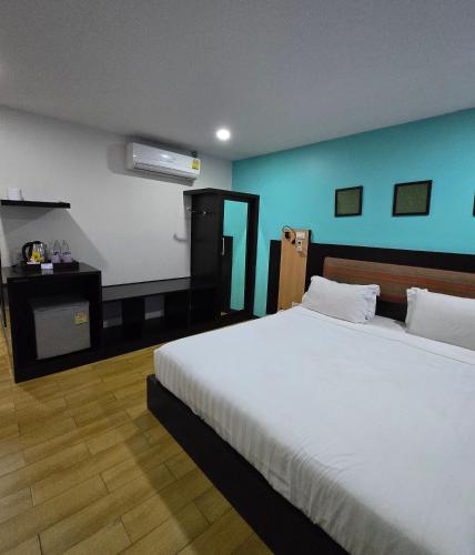 a bedroom with a large white bed and a blue wall at Residency Hotel Bangkok in Bangkok