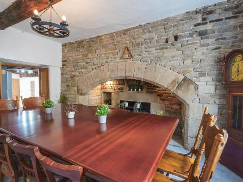 a dining room with a table and a stone fireplace at The Old Bulls Head in Chapel en le Frith
