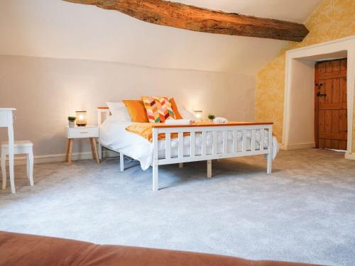 a bedroom with a white bed and a table at The Old Bulls Head in Chapel en le Frith