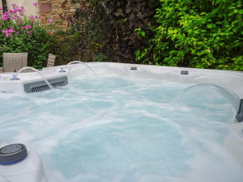 a hot tub with blue water in a backyard at The Old Bulls Head in Chapel en le Frith