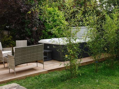 a wooden deck with two chairs and a hot tub at The Old Bulls Head in Chapel en le Frith