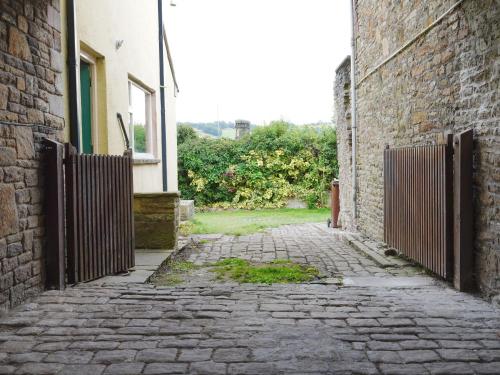 an alley with a gate next to a building at The Old Bulls Head in Chapel en le Frith