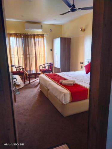 a bedroom with a large bed with a red blanket at Maa Paradise World in Alīpur Duār
