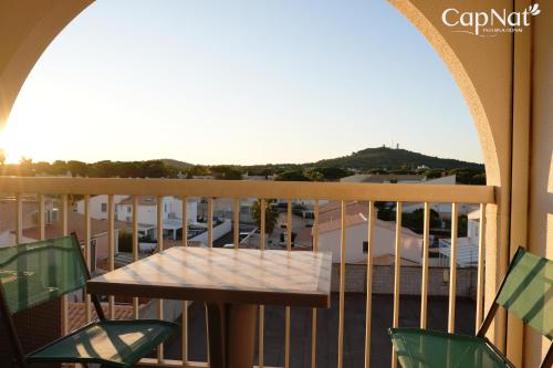 un balcon avec une table et des chaises sur un balcon dans l'établissement CapNat - Village Naturiste - Port Soleil - Le Capri Sun, au Cap d'Agde