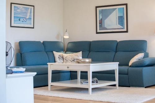 un soggiorno con un divano blu e un tavolo di Ferienwohnung Luv a Gelting