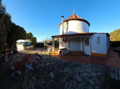 a small white chapel with a table and a building at Windmill House in Encarnação