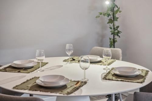 a white table with plates and wine glasses on it at King David Suites by Homie in Funchal