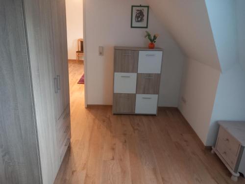 a room with a wooden floor and a dresser at Villa Parkhaus in Wernigerode