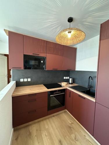 une cuisine avec des placards violets et un plafond dans l'établissement Casa Saint Denis, à Labenne