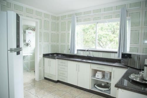 Η κουζίνα ή μικρή κουζίνα στο Conforto e Localização no Coração de POA SK1661