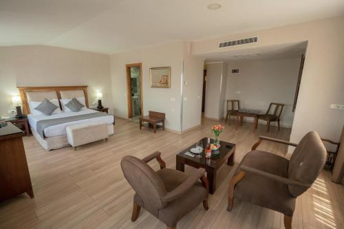a bedroom with a bed and a living room with chairs at The Green Park Taksim in Istanbul