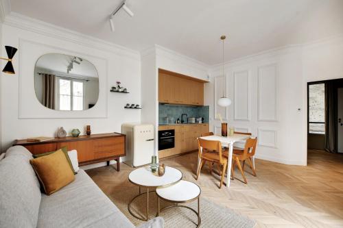 un salon et une cuisine avec un canapé et une table dans l'établissement Wonderful Apartment - Bastille, à Paris