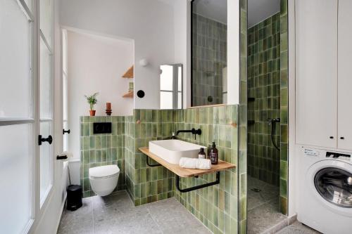une salle de bain avec un lavabo et une machine à laver dans l'établissement Wonderful Apartment - Bastille, à Paris