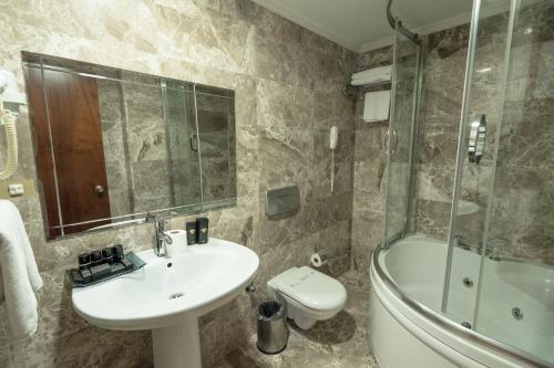 a bathroom with a sink and a toilet and a shower at The Green Park Taksim in Istanbul