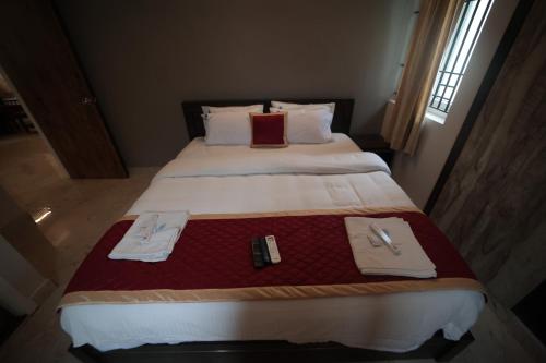 a bedroom with a large bed with two utensils on it at Shanthi Service Apartment in Madurai