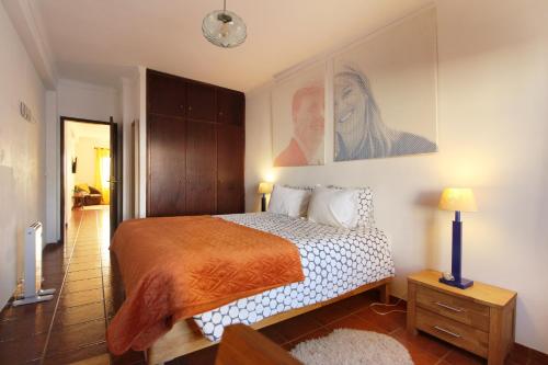a bedroom with a bed and a painting on the wall at Dutch house 200m from beach in Vila Nova de Milfontes