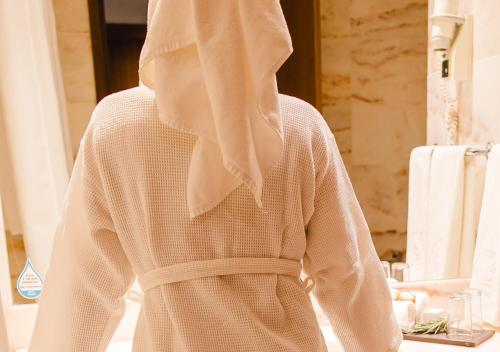 a woman with a towel on her back in a bathroom at Evora Hotel in Évora