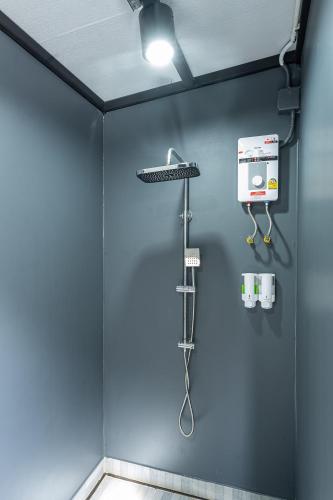 a bathroom with a blue wall with a shower at 44 Residence and Resort in Khlong Luang