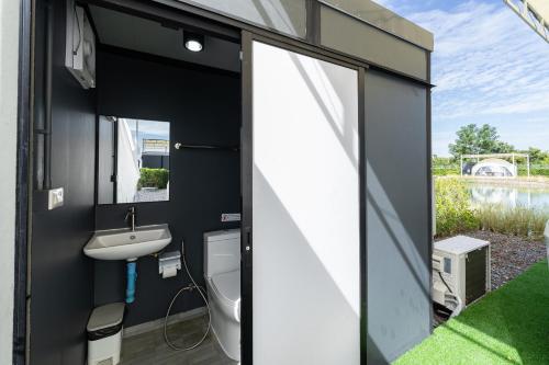 a small bathroom with a toilet and a sink at 44 Residence and Resort in Khlong Luang