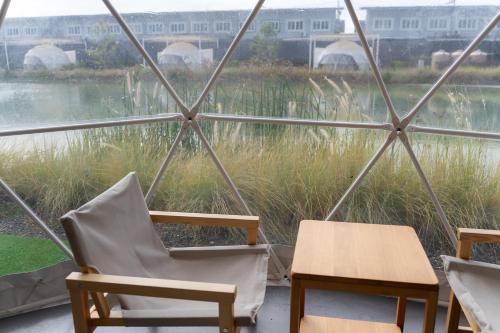 two chairs and a table in front of a window at 44 Residence and Resort in Khlong Luang