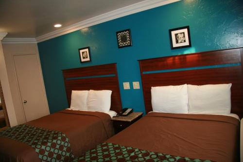 a hotel room with two beds and a blue wall at Civic Center Lodge / Lake Merritt BART in Oakland