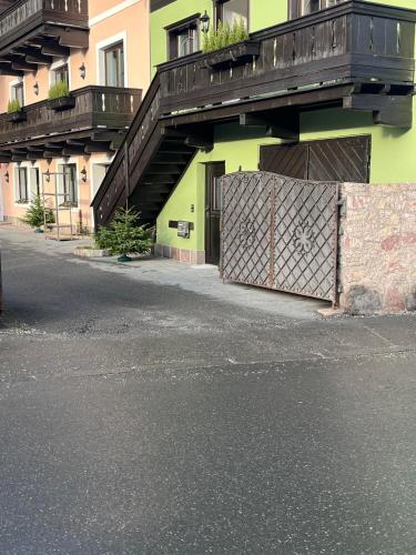 a building with a fence and a gate with a balcony at Mountain King Chalet in Kitzbühel