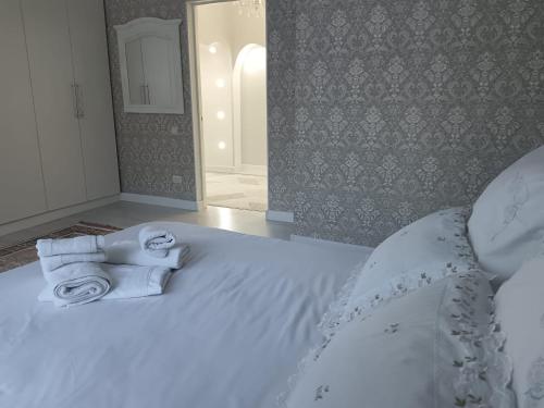 a bedroom with a white bed with towels on it at Светлая двухкомнатная квартира с Wi-Fi стильный дизайн и всё необходимое in Aktobe