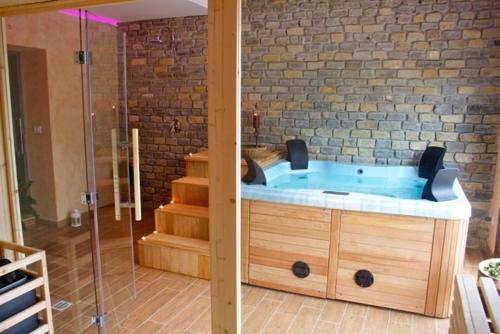 a bathroom with a jacuzzi tub next to a brick wall at Agriturismo Monaco Di Mezzo in Resuttano
