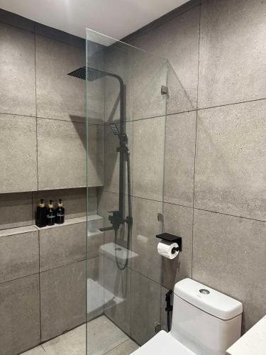 a bathroom with a glass shower with a toilet at Caldwell Boutique Hotel in Legazpi