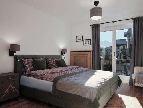 a bedroom with a large bed and a large window at Mountain King Chalet in Kitzbühel